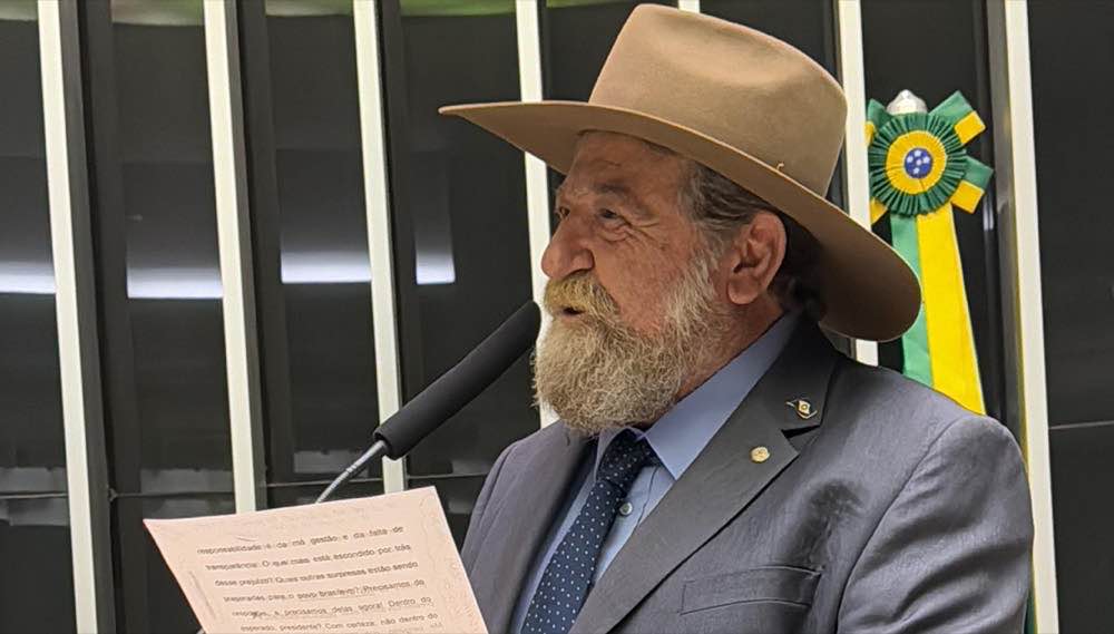 Nelson Barbudo na tribuna da Câmara, de chapéu, lendo um discurso